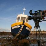 A small fishing boat, near the lighthouse "Ile Vierge"